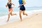 Fitness. Athletic Runners Legs Running On Beach. Exercising. Healthy Lifestyle