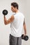 Fitness, back or man in dumbbell workout or training for wellness in studio on grey background. Strong male athlete