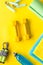 Fitness background - dumbbells, jump rope, sport carpet, water bottle - on yellow top-down