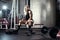 Fitness blonde woman posing on bench in the gym