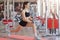 Fitness caucasian girl doing stretching workout on floor at gym. Full length shot of young girl in fitness centre. Athletic female