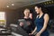 Fitness coach helps woman on elliptical trainer