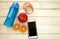 Fitness concept,exercise for losing weight with sport set,measure tape,smart phone,drinking bottle ,fresh fruit on white wood floo