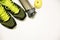 Fitness concept photo. Trainers, bottle of water and fruit apple are lying on white wooden table. Healthy lifestyle. Sport