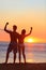 Fitness couple cheering at beach sunset