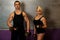 Fitness couple trains in gym with dumbbells