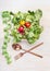 Fitness dieting salad with cutlery and measuring tape on white wooden background, top view. Mixed greens salad bowl