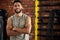 Fitness, earphones and portrait of man in gym, arms crossed and confident smile in mockup space. Happiness, workout and