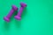 Fitness equipment with womens purple weights/ dumbbells isolated on a teal green background with copyspace