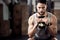 Fitness, exercise and man squat with a kettlebell at gym for a training workout with focus. Serious male athlete or
