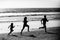 Fitness family running on a sandy beach. Sporty family father, mother and baby son running together. Child with parents