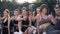 Fitness female good-looking group sitting on the outdoor stadium`s floor and showing sign ok on camera after fitness