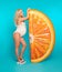 Fitness. Fit blond pregnant woman expecting maternity with her belly by orange inflatable mattress isolated on studio blue