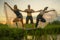 Fitness and friendship - young happy and attractive group of friends doing acro yoga workout playful on rice field with beautiful