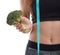 Fitness girl in black top with centimeter ribbon holds in hand broccoli on white isolated background
