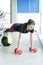 Fitness girl doing dumbbells and medicine ball plank. Woman doing floor workout at gym