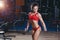 Fitness girl with healthy sporty figure with skipping rope in gym