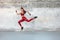 Fitness Girl Jumping. Outdoor Workout Against Concrete Wall At Stadium. Fashion Sporty Female With Strong Sexy Body.