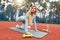 Fitness girl with long blond hair doing donkey kicks exercise with red fabric booty band gum during her sport workout on