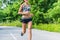 Fitness girl running in summer outdoor nature park