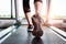 Fitness girl running on treadmill, Woman with muscular legs in g