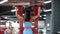 Fitness girl training pull ups exercises in sport machine in gym club. Woman bodybuilder pulling up in fitness machine