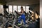 Fitness girl trains on an elliptical trainer in modern gym. Young woman is engaged in sports on the orbitrek