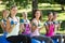 Fitness group lifting hand weights in park