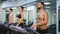 Fitness happy woman and man on stationary bicycle doing spinning at gym. Fit young woman working out on bike with man