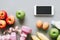 Fitness and healthy active lifestyle background concept. Dumbbell, milk bottle, apples, eggs, bananas and smart phone, tape meas