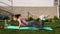 Fitness, home and diet concept - Gorgeous brunette woman warming up and doing some push ups on the yoga mat outdoors at