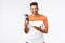 Fitness instructor holding water bottle and pointing at it as recommend drink after workout. Handsome mascular man share