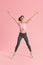 Fitness jump. Woman doing jumping exercise on pink background