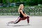 Fitness lifestyle. Young woman doing lunges to the side. Workout at the stadium. Healthy life concept. Horizontal photo