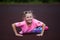 Fitness little girl resting after exercises at stadium. Sport girl posing at stadium. Fitness girl with a sports figure in