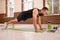 Fitness man in black sports wear doing up push ups exercise in empty gym or home watching online sports videos. Muscular