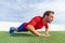 Fitness man doing diamond hand push ups exercises at outdoor grass park. Core body workout athlete planking or doing