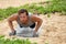 Fitness man doing plank push-ups exercise on dumbbell weights on beach. Bodyweight floor exercises healthy lifestyle