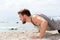 Fitness man doing push-up exercise on beach