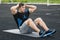 Fitness man doing sit ups in the stadium, working out. Active male exercising abdominals