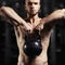 Fitness man doing a weight training by lifting heavy kettlebell