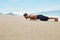 Fitness Man Exercising, Doing Push Ups Exercise On Beach. Sports