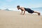 Fitness Man Exercising, Doing Push Ups Exercise On Beach. Sports