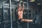 Fitness man hanging on horizontal bar performing legs raises, in the gym