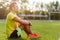 Fitness man sitting on grass and resting after sport exercises