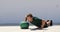 Fitness man strength training pushup chest and shoulder muscles doing alternating single arm medicine ball push-ups