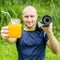 Fitness man with yoga mat holding a glass of orange juice