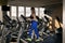 Fitness model trains on an elliptical trainer in modern gym. Young woman is engaged in sports on the orbitrek