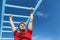 Fitness monkey bars man training arms muscles on jungle gym outdoors in summer. Athlete working out gripping climbing on