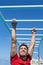 Fitness monkey bars man training arms muscles on jungle gym outdoors in summer. Athlete working out gripping climbing on